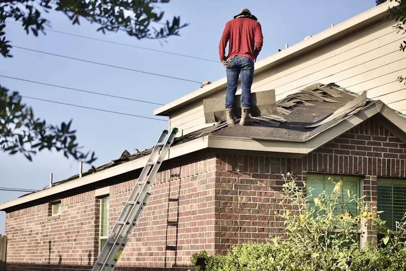 Professional roofer working on a residential roof in Welch